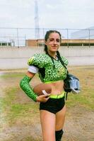 Porträt von Mexikaner Frau amerikanisch Fußball Spieler tragen Uniform mit Velociraptor Haut Muster foto