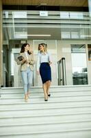 zwei jung Geschäft Frauen Gehen auf Treppe im das Büro Flur foto