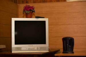 retro Fernseher auf das Tabelle im das Zimmer auf ein hölzern Hintergrund. foto