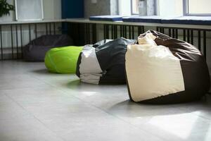 ruhen Platz beim arbeiten. ein Reihe von verstreut mehrfarbig Tasche Stühle im ein leeren Büro. foto