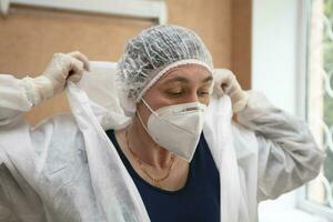 ein Arzt setzt auf ein schützend passen im ein Krankenhaus während ein Coronavirus Epidemie. foto