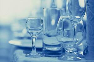 Glas Becher auf das Restaurant Tabelle getönt im Blau. foto