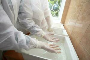 Hand Reinigung mit Desinfektionsmittel Lösung im das Krankenhaus Tor während das Coronavirus Epidemie. foto