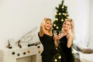 Weihnachten. Bankett. zwei glücklich festlich jung Mode Frauen mit Wein Brille von Champagner Toasten - - Neu Jahr foto