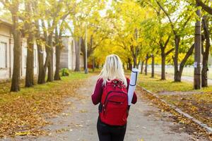 Mädchen mit ein Rucksack im das Herbst Park foto