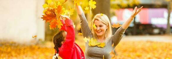 glücklich Elternteil und Kind halten Herbst Gelb Blätter draussen. foto