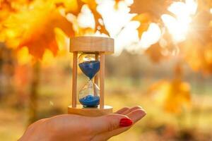 Uhr, Sanduhren und Herbst Blätter foto