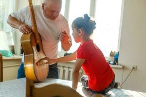 Nahansicht des Mannes Hand Ändern Saiten auf seine alt akustisch Gitarre. foto