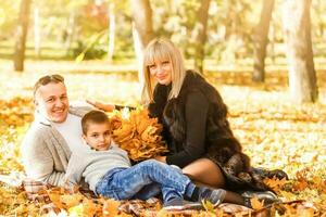 Mutter, Papa und Töchter abspielen im Ahorn Blätter Stapel foto