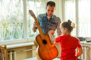 Nahansicht des Mannes Hand Ändern Saiten auf seine alt akustisch Gitarre. foto