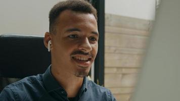 junger Mann, der Kopfhörer trägt, die im Online-Treffen sprechen