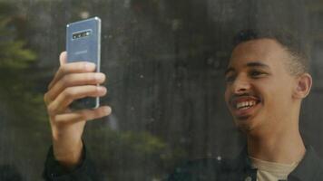 Porträt eines fröhlichen jungen Mannes bei einem Smartphone-Videoanruf foto