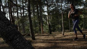 Porträt der jungen Frau, die im Wald läuft foto