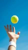 Hand von ein Mann werfen Tennis Ball. ai generiert foto