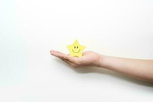 Hand halten Gelb Star glücklich Lächeln Gesicht, gut Feedback Bewertung und positiv Kunde Rezension, Erfahrung, Befriedigung Umfrage, mental Gesundheit Bewertung, Kompliment. foto