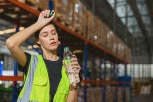 müde Stress Frau Mitarbeiter Arbeiter Schweiß von heiß Wetter im Sommer- Arbeiten im Warenhaus Waren Ladung Versand Logistik Industrie. foto