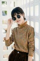 asiatisch Teen warnen runden Sonnenbrille im Jahrgang Stil Kleid Sommer- Mode Sammlung Modell- Porträt. foto