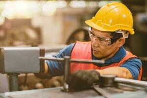 männlich Mechaniker Arbeiter mit Sicherheit Helm Arbeiten Arbeit im Metall Industrie Fabrik mit Stahl Bearbeitung. foto