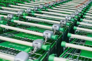 Reihe geparkter Trolleys oder Einkaufswagen im Supermarkt foto