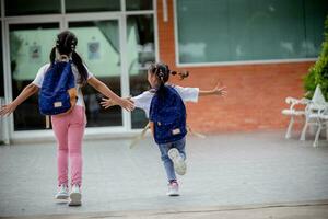 zurück zu Schule. süß asiatisch Kind Mädchen mit ein Rucksack Laufen und gehen zu Schule mit Spaß foto