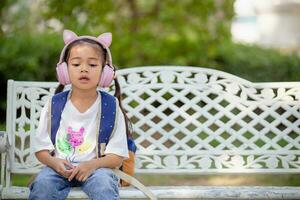 asiatisch Mädchen Hören zu Musik- auf Smartphone beim Schule, mit kabellos Headset und Handy, Mobiltelefon Anwendung foto