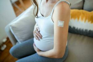 Klebstoff Binde auf Arm nach Injektion Impfstoff oder Medizin, Klebstoff Bandagen Gips - - medizinisch Ausrüstung, weich Fokus Klebstoff Binde auf ein schwanger weiblich brachium nach covid-19 Impfung foto