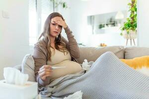 jung schwanger Frau Lügen im Bett, Messung Körper Temperatur, halten Thermometer Gefühl krank foto