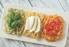 Pasta mit Basilikum, Mozzarella und Kirsche Tomaten foto