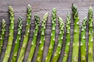 frischer Spargel auf dem hölzernen Hintergrund foto