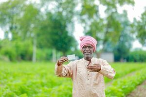 indisch Farmer halten gullak im Hand, Speichern Konzept, glücklich Arm Farmer foto