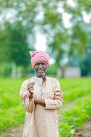 indisch Farmer halten gullak im Hand, Speichern Konzept, glücklich Arm Farmer foto