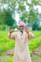 indisch Farmer halten gullak im Hand, Speichern Konzept, glücklich Arm Farmer foto