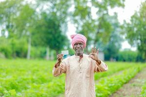 indisch Farmer halten gullak im Hand, Speichern Konzept, glücklich Arm Farmer foto