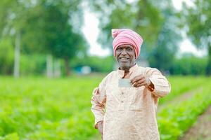 indisch Farmer halten gullak im Hand, Speichern Konzept, glücklich Arm Farmer foto