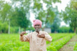 indisch Farmer halten gullak im Hand, Speichern Konzept, glücklich Arm Farmer foto