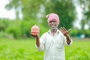 indisch Farmer halten gullak im Hand, Speichern Konzept, glücklich Arm Farmer foto