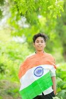 indisch Junge halten National Flagge im Bauernhof, glücklich Junge, National Flagge foto