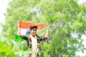 indisch Junge halten National Flagge im Bauernhof, glücklich Junge, National Flagge foto