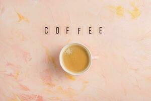 Tasse von Espresso Kaffee und Text Kaffee auf Rosa Hintergrund foto