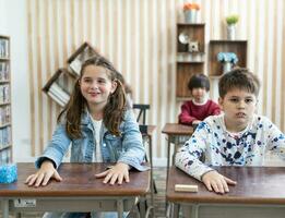 glücklich lächelnd Junge und Mädchen Schule Kinder studieren zusammen mit Tablette Gerät im Klassenzimmer. Gruppen von Schulkinder Arbeiten auf Aufgabe. Bildung Konzept. foto