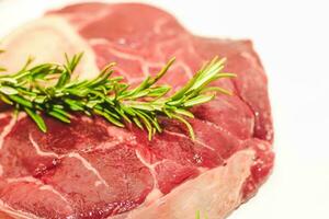 frisch Stück von Fleisch groß Rindfleisch Steak auf das Knochen Markknochen mit Rosmarin Zweig foto