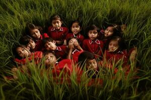 ein Gruppe von wenig Kinder Sitzung im das Gras foto