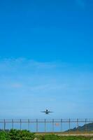 das Flugzeug war fliegend Über das Wände von Phuket Flughafen beim gerade das richtig Zeit. gegen das Hintergrund von das Blau Himmel foto