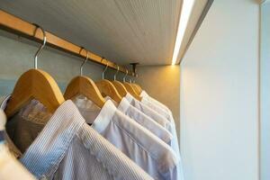 Kleiderschrank mit Kleider hängend auf Schiene foto