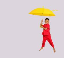 Junge Mode ein chinesischer Stil Hemd halten ein Gelb Regenschirm posiert zum ein Foto schießen.