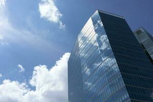 Wolkenkratzer, Hochhaus Gebäude von Winkel Aussicht auf Hintergrund von Himmel. Stadtbild, Turm im städtisch Bereich. Geschäft Entwicklung oder finanziell Center Konzept. Kopieren Raum auf links. modern Gebäude. horizontal foto