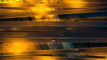 Luftaufnahme von oben auf die Autobahn, Verkehrsknotenpunktstraße mit dem Auto auf der Kreuzungskreuzung in der Nacht foto