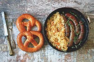 bayerische Würstchen in der Pfanne mit gedünstetem Sauerkraut oktoberfest Essen foto