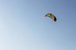 leuchtend farbiger Fallschirm vom Kitesurfen am blauen Himmel. Platz für Text foto