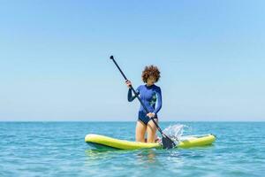 Frau mit Paddel auf Paddel Boot im Meer foto